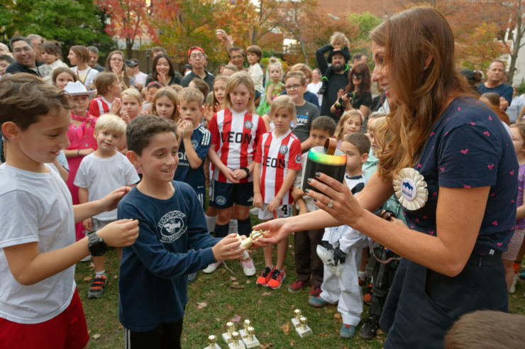 Event co-chair Erica Martini hands out golden pumpkin trophies for the Most Realistic winning entry, “Shake Shack,” by Blake and Logan (top), and to Mason and Ryan Wertheimer (above) whose family, the Miller-Wertheimer’s, won the Funniest category. Their entry: “Boo!-ba Tea. Photos: Carl Glassman/Tribeca Trib